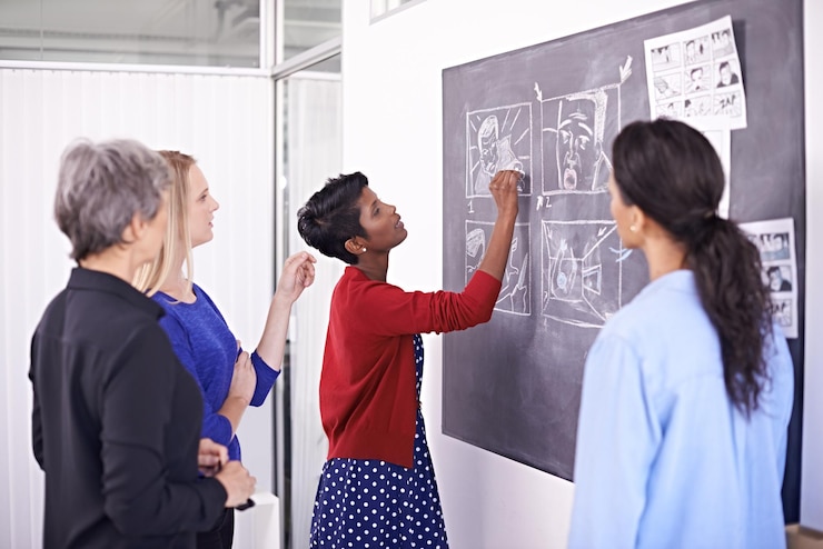 Colleagues pinning notes to a chalkboard wall